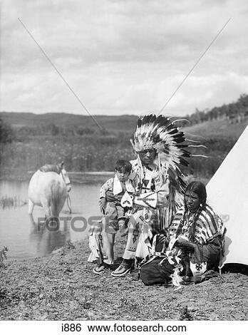 1920S Native American Family Man Woman Child Horse By Tepee Full Feathered Beaded Costume Stoney Sioux Tribe Alberta Canada View Large Photo Image Stock Photograph - 1920S Native American Family Man Woman Child Horse By Tepee Full Feathered Beaded Costume Stoney Sioux Tribe Alberta Canada. Fotosearch