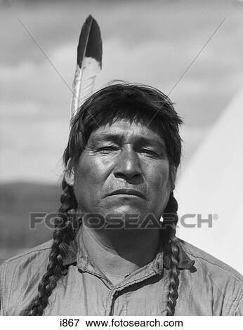 1920S Portrait Native American Man Looking At Camera Serious Expression Single Feather Stoney Sioux Alberta Canada View Large Photo Image Stock Photo - 1920S Portrait Native American Man Looking At Camera Serious Expression Single Feather Stoney Sioux Alberta Canada. Fotosearch