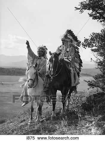1920S Two Native American Indian Men On Horseback In Full Feather Headdress Stoney Sioux Tribe Alberta Canada View Large Photo Image Stock Photography - 1920S Two Native American Indian Men On Horseback In Full Feather Headdress Stoney Sioux Tribe Alberta Canada . Fotosearch