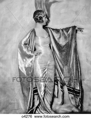 1920s WOMAN IN ELABORATE SILK GOWN AND CAPE ZIEGFELD FOLLIES SHOWGIRL FASHION NEW YORK CITY USA View Large Photo Image Stock Photograph - 1920s WOMAN IN ELABORATE SILK GOWN AND CAPE ZIEGFELD FOLLIES SHOWGIRL FASHION NEW YORK CITY USA. Fotosearch