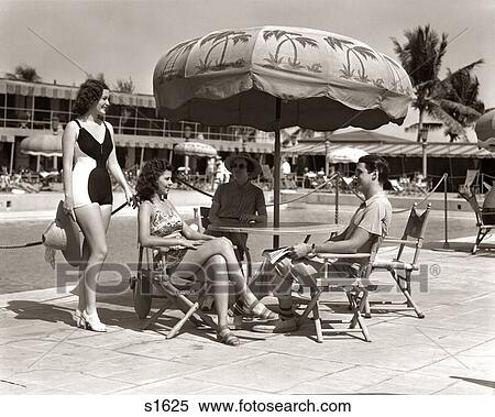 1930s 1940s 3 WOMEN BATHING SUITS SINGLE MAN CASUAL CLOTHES SITTING TALKING UNDER POOL SIDE UMBRELLA MIAMI BEACH FLORIDA USA View Large Photo Image Stock Photography - 1930s 1940s 3 WOMEN BATHING SUITS SINGLE MAN CASUAL CLOTHES SITTING TALKING UNDER POOL SIDE UMBRELLA MIAMI BEACH FLORIDA USA. Fotosearch