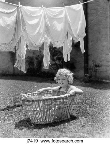 1930s 1940s GIRL OUTDOORS SITTING IN LAUNDRY BASKET UNDER CLOTHESLINE FULL OF SHIRTS View Large Photo Image Stock Photo - 1930s 1940s GIRL OUTDOORS SITTING IN LAUNDRY BASKET UNDER CLOTHESLINE FULL OF SHIRTS. Fotosearch