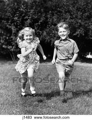 1930s 1940s SMILING BOY AND GIRL RUNNING IN SUMMER BACKYARD GRASS LOOKING AT CAMERA View Large Photo Image Stock Image - 1930s 1940s SMILING BOY AND GIRL RUNNING IN SUMMER BACKYARD GRASS LOOKING AT CAMERA. Fotosearch