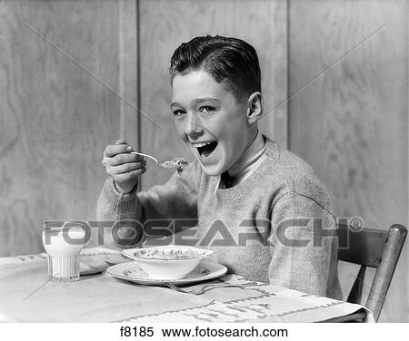 1930S 1940S Smiling Boy Looking At Camera Eating Breakfast Bowl Of Cereal And Glass Of Milk View Large Photo Image Stock Photography - 1930S 1940S Smiling Boy Looking At Camera Eating Breakfast Bowl Of Cereal And Glass Of Milk. Fotosearch