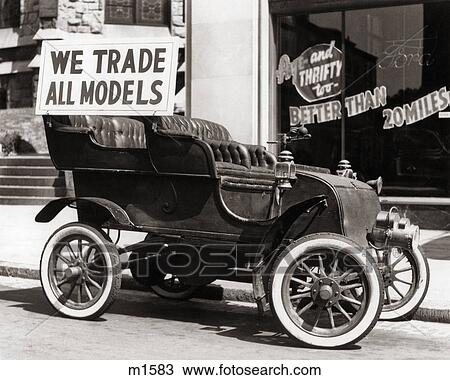 1930s ANTIQUE CAR WITH WE TRADE ALL MODELS ADVERTISING SIGN PARKED ON STREET IN FRONT OF CAR DEALERSHIP View Large Photo Image Stock Image - 1930s ANTIQUE CAR WITH WE TRADE ALL MODELS ADVERTISING SIGN PARKED ON STREET IN FRONT OF CAR DEALERSHIP. Fotosearch