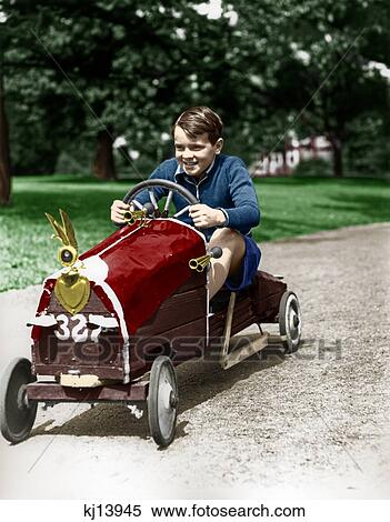 Stock Photography - 1930S Boy Driving Home Built Race Car Holding Steering Wheel. Fotosearch