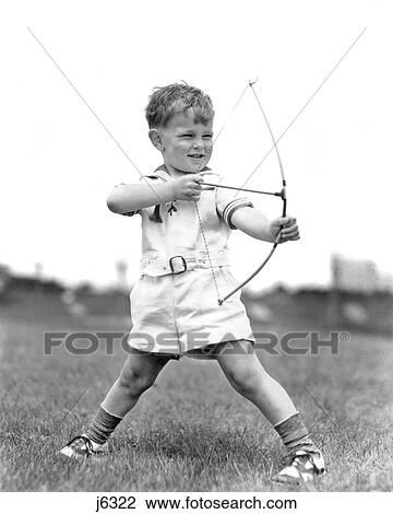 1930s BOY OUTDOORS AIMING TOY BOW AND ARROW ARCHERY View Large Photo Image Stock Image - 1930s BOY OUTDOORS AIMING TOY BOW AND ARROW ARCHERY. Fotosearch