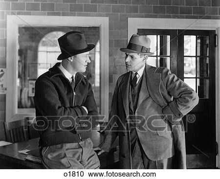1930s BUSINESSMAN IN SUIT TALKING WITH WORKING MAN EMPLOYEE WEARING JACKET SERIOUS EXPRESSIONS CONVERSATION ON THE JOB View Large Photo Image Stock Image - 1930s BUSINESSMAN IN SUIT TALKING WITH WORKING MAN EMPLOYEE WEARING JACKET SERIOUS EXPRESSIONS CONVERSATION ON THE JOB. Fotosearch