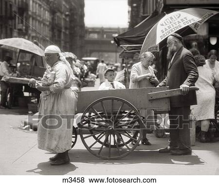 1930s DEPRESSION ERA LOWER EAST SIDE PUSHCART SCENE WITH EASTERN EUROPEAN IMMIGRANT VENDORS AND CUSTOMERS NEW YORK CITY USA View Large Photo Image Stock Photo - 1930s DEPRESSION ERA LOWER EAST SIDE PUSHCART SCENE WITH EASTERN EUROPEAN IMMIGRANT VENDORS AND CUSTOMERS NEW YORK CITY USA. Fotosearch