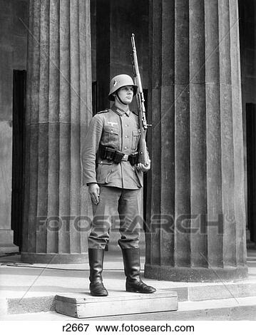Stock Photo - 1930s GERMAN SOLDIER AT ATTENTION RIFLE ON SHOULDER STANDING GUARD STEPS TOMB OF UNKNOWN SOLDIER BERLIN GERMANY. Fotosearch