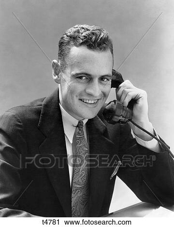 1930s MAN TALKING ON TELEPHONE LOOKING AT CAMERA View Large Photo Image Stock Image - 1930s MAN TALKING ON TELEPHONE LOOKING AT CAMERA. Fotosearch