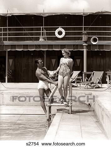 Picture - 1930s MAN WOMAN COUPLE IN BATHING SUITS POOL SIDE VACATION HOTEL MIAMI BEACH FLORIDA USA. Fotosearch