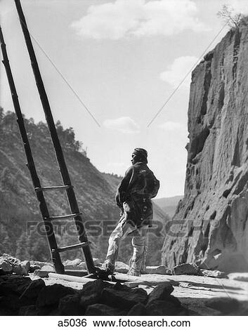 1930s NATIVE AMERICAN INDIAN MAN BY KIVA LADDER FRIJOLES CANYON CEREMONIAL KIVA BANDELIER NATIONAL MONUMENT NEW MEXICO USA View Large Photo Image Stock Photograph - 1930s NATIVE AMERICAN INDIAN MAN BY KIVA LADDER FRIJOLES CANYON CEREMONIAL KIVA BANDELIER NATIONAL MONUMENT NEW MEXICO USA. Fotosearch