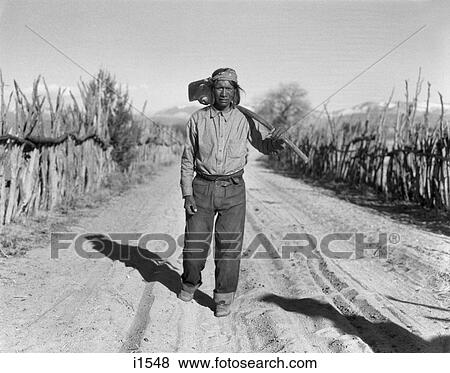 1930s NATIVE AMERICAN INDIAN MAN FARMER WALKING ROAD CARRYING FARM TOOL HOE SAN ILDEFONSO PUEBLO NEW MEXICO USA View Large Photo Image Stock Photo - 1930s NATIVE AMERICAN INDIAN MAN FARMER WALKING ROAD CARRYING FARM TOOL HOE SAN ILDEFONSO PUEBLO NEW MEXICO USA. Fotosearch