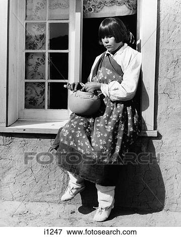 1930s NATIVE AMERICAN WOMAN SITTING ON WINDOWSILL DECORATING POTTERY WEARING TYPICAL COSTUME SAN ILDEFONSO PUEBLO NEW MEXICO USA View Large Photo Image Stock Photo - 1930s NATIVE AMERICAN WOMAN SITTING ON WINDOWSILL DECORATING POTTERY WEARING TYPICAL COSTUME SAN ILDEFONSO PUEBLO NEW MEXICO USA. Fotosearch