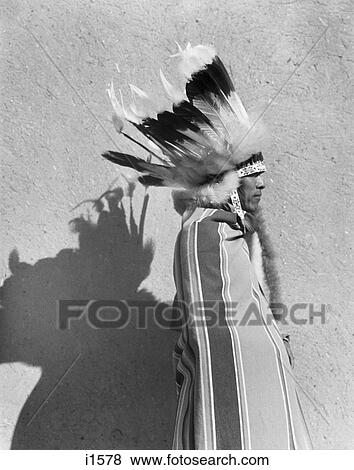 1930s PORTRAIT NATIVE AMERICAN INDIAN MAN WEARING FULL FEATHERED HEADDRESS FEATHER BONNET SAN ILDEFONSO PUEBLO NEW MEXICO USA View Large Photo Image Stock Photo - 1930s PORTRAIT NATIVE AMERICAN INDIAN MAN WEARING FULL FEATHERED HEADDRESS FEATHER BONNET SAN ILDEFONSO PUEBLO NEW MEXICO USA. Fotosearch