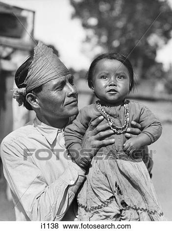 1930s PROUD NATIVE AMERICAN INDIAN NAVAJO MAN FATHER HOLDING BABY GIRL DAUGHTER LOOKING AT CAMERA View Large Photo Image Stock Photo - 1930s PROUD NATIVE AMERICAN INDIAN NAVAJO MAN FATHER HOLDING BABY GIRL DAUGHTER LOOKING AT CAMERA. Fotosearch