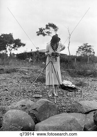 1930S Smartly Dressed Woman Photographer Looking Through View Finder Of Camera On Tripod View Large Photo Image Picture - 1930S Smartly Dressed Woman Photographer Looking Through View Finder Of Camera On Tripod. Fotosearch