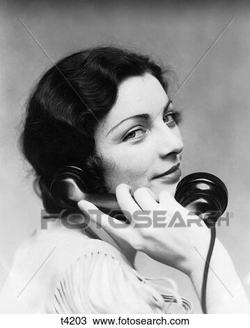 1930S Smiling Brunette Woman Talking On Telephone Looking At Camera Back Over Her Shoulder View Large Photo Image Stock Image - 1930S Smiling Brunette Woman Talking On Telephone Looking At Camera Back Over Her Shoulder. Fotosearch