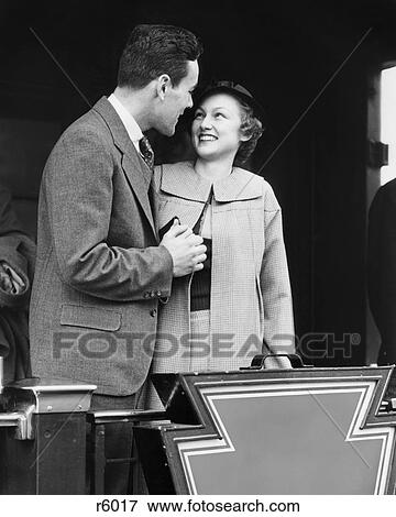 1930s SMILING COUPLE MAN WOMAN HOLDING HANDS STANDING ON REAR PLATFORM OF TRAIN OBSERVATION CAR View Large Photo Image Stock Photo - 1930s SMILING COUPLE MAN WOMAN HOLDING HANDS STANDING ON REAR PLATFORM OF TRAIN OBSERVATION CAR. Fotosearch