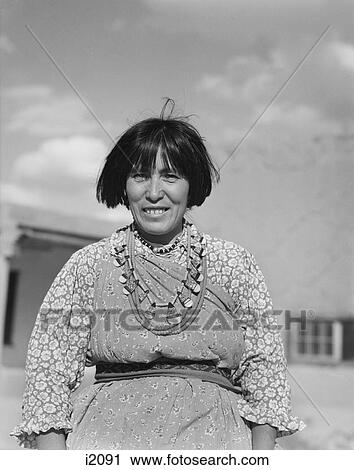 Stock Image - 1930S Smiling Native American Indian Woman Wearing Typical Dress & Jewelry Looking At Camera San Ildefonso Pueblo New Mexico Usa. Fotosearch