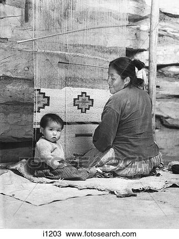 1930s SMILING NATIVE AMERICAN NAVAJO WOMAN MOTHER WEAVING RUG SEATED AT LOOM WITH BABY AT HER SIDE LOOKING AT CAMERA View Large Photo Image Stock Image - 1930s SMILING NATIVE AMERICAN NAVAJO WOMAN MOTHER WEAVING RUG SEATED AT LOOM WITH BABY AT HER SIDE LOOKING AT CAMERA. Fotosearch
