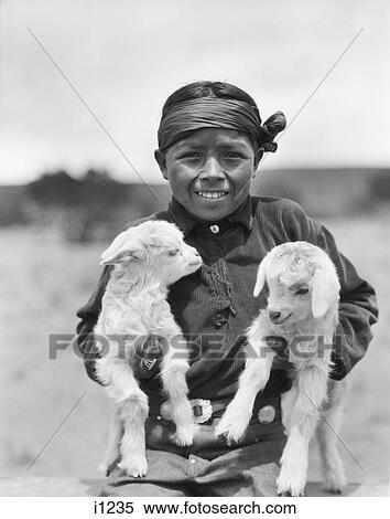 1930S Smiling Native American Navajo Boy Looking At Camera Holding Two Baby Lambs New Mexico Usa View Large Photo Image Stock Photography - 1930S Smiling Native American Navajo Boy Looking At Camera Holding Two Baby Lambs New Mexico Usa. Fotosearch