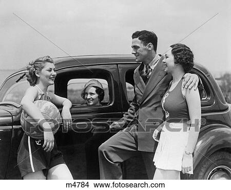 1930S Two Women In Nautical Theme Clothes And Man In A Suit Talking Standing By Third Woman In Parked Automobile At Seashore View Large Photo Image Picture - 1930S Two Women In Nautical Theme Clothes And Man In A Suit Talking Standing By Third Woman In Parked Automobile At Seashore. Fotosearch