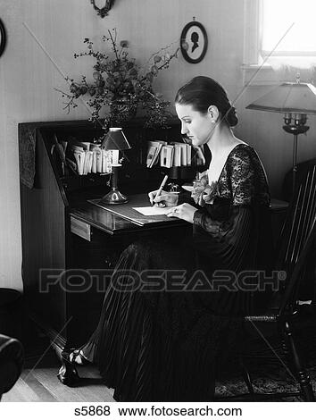 1930s WOMAN SITTING AT DESK WRITING LETTER View Large Photo Image Stock Photo - 1930s WOMAN SITTING AT DESK WRITING LETTER. Fotosearch