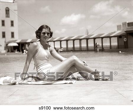 1930s WOMAN SITTING POOL SIDE LOOKING AT CAMERA WEARING FASHIONABLE SUNGLASSES BATHING SUIT AND SANDALS MIAMI BEACH FLORIDA USA View Large Photo Image Stock Image - 1930s WOMAN SITTING POOL SIDE LOOKING AT CAMERA WEARING FASHIONABLE SUNGLASSES BATHING SUIT AND SANDALS MIAMI BEACH FLORIDA USA. Fotosearch