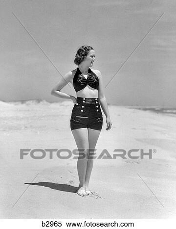 1930s WOMAN STANDING ON BEACH WEARING TWO PIECE BATHING SUIT View Large Photo Image Stock Photography - 1930s WOMAN STANDING ON BEACH WEARING TWO PIECE BATHING SUIT. Fotosearch