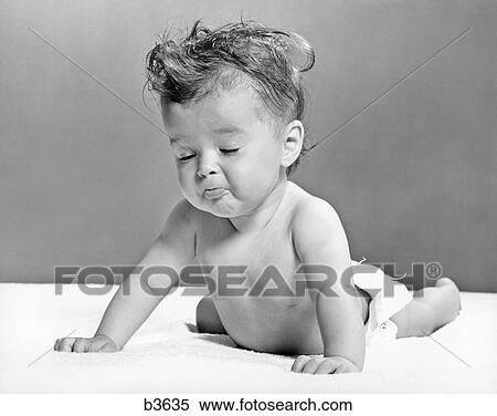 Stock Photography - 1940s 1950s BABY LYING ON STOMACH LEANING ON HANDS EYES CLOSED. Fotosearch