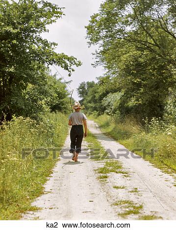 1940s 1950s BAREFOOT BOY WALKING DOWN COUNTRY LANE IN SUMMER WITH TWIG FISHING POLE ON HIS SHOULDER View Large Photo Image Stock Image - 1940s 1950s BAREFOOT BOY WALKING DOWN COUNTRY LANE IN SUMMER WITH TWIG FISHING POLE ON HIS SHOULDER. Fotosearch