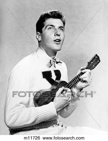 1940s 1950s COLLEGE BOY WEARING X LETTER SWEATER SINGING AND PLAYING UKULELE View Large Photo Image Stock Photograph - 1940s 1950s COLLEGE BOY WEARING X LETTER SWEATER SINGING AND PLAYING UKULELE. Fotosearch