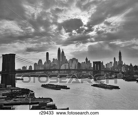 1940S 1950S Dramatic Sunset Downtown New York City Skyline With Brooklyn Bridge Barges In East River Nyc Ny Usa View Large Photo Image Stock Image - 1940S 1950S Dramatic Sunset Downtown New York City Skyline With Brooklyn Bridge Barges In East River Nyc Ny Usa. Fotosearch