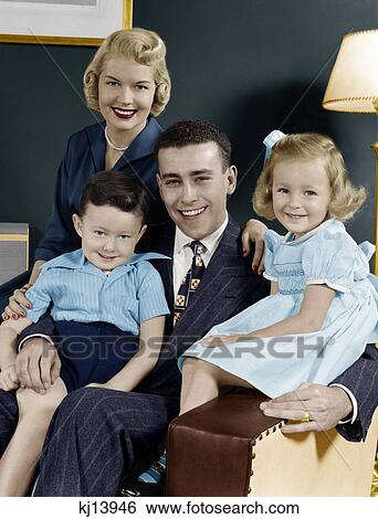 1940S 1950S Family Of Four Portrait Sitting In Living Room Chair Looking At Camera View Large Photo Image Stock Photograph - 1940S 1950S Family Of Four Portrait Sitting In Living Room Chair Looking At Camera. Fotosearch