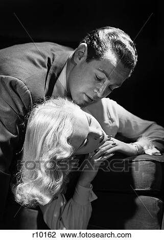 1940s 1950s GLAMOROUS STUDIO STYLE ROMANTIC COUPLE ON SOFA MAN LEANING CHIN ON WOMANS SHOULDER ABOUT TO KISS LONG BLOND HAIR View Large Photo Image Stock Image - 1940s 1950s GLAMOROUS STUDIO STYLE ROMANTIC COUPLE ON SOFA MAN LEANING CHIN ON WOMANS SHOULDER ABOUT TO KISS LONG BLOND HAIR. Fotosearch