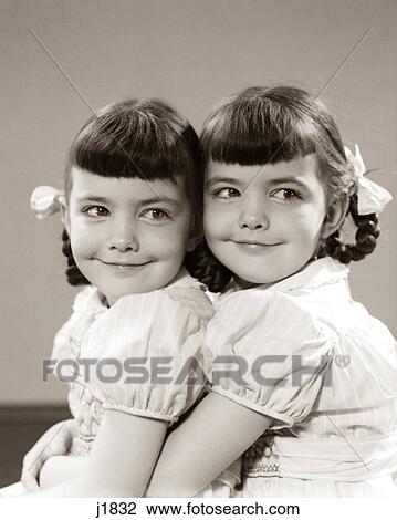 1940s 1950s TWIN GIRLS SMILING HUGGING View Large Photo Image Stock Image - 1940s 1950s TWIN GIRLS SMILING HUGGING. Fotosearch