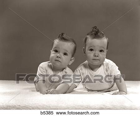 1940s 1950s TWIN INFANT BABY BOYS LYING SIDE BY SIDE LOOKING AT CAMERA View Large Photo Image Stock Photography - 1940s 1950s TWIN INFANT BABY BOYS LYING SIDE BY SIDE LOOKING AT CAMERA. Fotosearch
