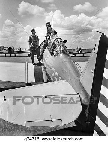 1940s 2 ARMY PILOTS STANDING FUSELAGE OF SLIDING COCKPIT SINGLE ENGINE AIRPLANE WING US ARMY AIR CORPS RANDOLPH FIELD TEXAS USA View Large Photo Image Stock Photo - 1940s 2 ARMY PILOTS STANDING FUSELAGE OF SLIDING COCKPIT SINGLE ENGINE AIRPLANE WING US ARMY AIR CORPS RANDOLPH FIELD TEXAS USA. Fotosearch