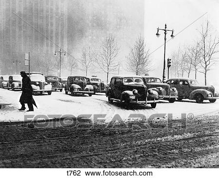 1940s ANONYMOUS SILHOUETTED PEDESTRIAN CROSSING CITY STREET IN WINTER WITH SNOW ON ROAD AND CAR TRAFFIC NYC NEW YORK USA View Large Photo Image Stock Image - 1940s ANONYMOUS SILHOUETTED PEDESTRIAN CROSSING CITY STREET IN WINTER WITH SNOW ON ROAD AND CAR TRAFFIC NYC NEW YORK USA. Fotosearch