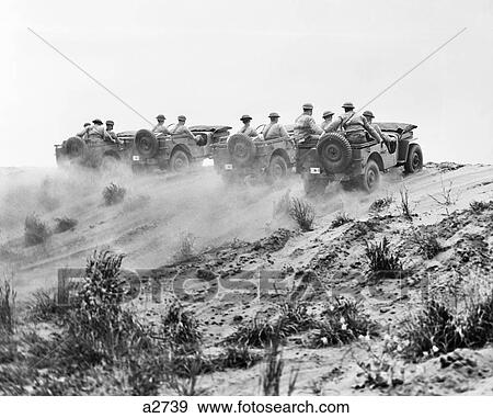 1940s ARMY SOLDIERS RIDING JEEPS IN FORMATION GOING UP A DUSTY HILL View Large Photo Image Stock Photo - 1940s ARMY SOLDIERS RIDING JEEPS IN FORMATION GOING UP A DUSTY HILL. Fotosearch