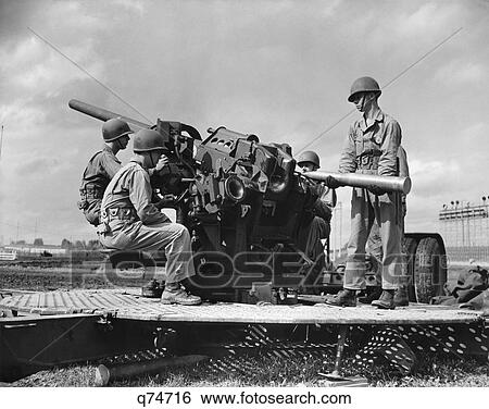 1940s CREW OF FOUR WORLD WAR II SOLDIERS MANNING ARTILLERY CANNON LOADING SHELL INTO BREECH OF GUN View Large Photo Image Stock Photograph - 1940s CREW OF FOUR WORLD WAR II SOLDIERS MANNING ARTILLERY CANNON LOADING SHELL INTO BREECH OF GUN. Fotosearch