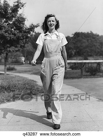 1940s HAPPY SMILING WOMAN FEMALE WORKER OUTDOOR WALKING TOWARD WEARING BIB OVERALLS COVERALLS WORK CLOTHES LOOKING AT CAMERA View Large Photo Image Stock Photo - 1940s HAPPY SMILING WOMAN FEMALE WORKER OUTDOOR WALKING TOWARD WEARING BIB OVERALLS COVERALLS WORK CLOTHES LOOKING AT CAMERA. Fotosearch