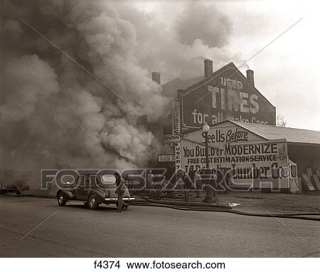 1940s SMOKE AND FIRE BILLOWING OUT OF A BURNING INDUSTRIAL COMMERCIAL BUILDING View Large Photo Image Picture - 1940s SMOKE AND FIRE BILLOWING OUT OF A BURNING INDUSTRIAL COMMERCIAL BUILDING. Fotosearch