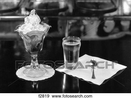 1940s STILL LIFE OF ICE CREAM SUNDAE GLASS OF WATER NAPKIN SPOON ON SODA FOUNTAIN COUNTER View Large Photo Image Stock Photo - 1940s STILL LIFE OF ICE CREAM SUNDAE GLASS OF WATER NAPKIN SPOON ON SODA FOUNTAIN COUNTER. Fotosearch