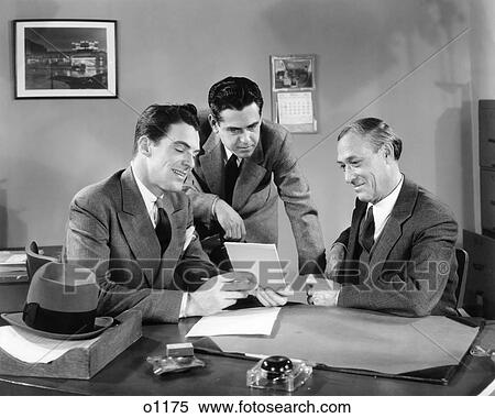 1940s THREE MEN AT OFFICE DESK LOOKING AT PAPERS TABLET MEETING View Large Photo Image Stock Photography - 1940s THREE MEN AT OFFICE DESK LOOKING AT PAPERS TABLET MEETING. Fotosearch