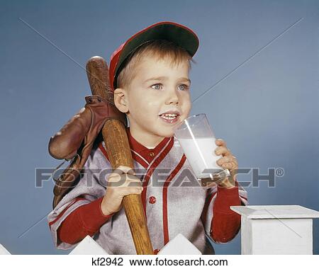 1950s 1960s BOY DRINKING MILK WEARING BASEBALL UNIFORM BY PICKET FENCE View Large Photo Image Stock Image - 1950s 1960s BOY DRINKING MILK WEARING BASEBALL UNIFORM BY PICKET FENCE. Fotosearch