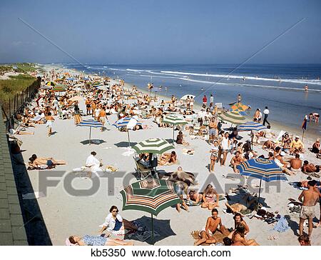 1950s 1960s CROWD OF PEOPLE ON SUMMER VACATION BEACH BY OCEAN WITH UMBRELLAS NEAR OGUNQUIT MAINE USA View Large Photo Image Stock Image - 1950s 1960s CROWD OF PEOPLE ON SUMMER VACATION BEACH BY OCEAN WITH UMBRELLAS NEAR OGUNQUIT MAINE USA. Fotosearch