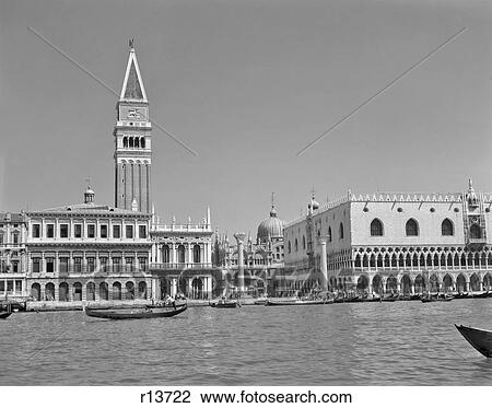 Stock Image - 1950s 1960s DOGES PALACE AND GONDOLAS IN HARBOR VENICE ITALY. Fotosearch